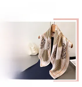 Detailed view of leopard print silk scarf with golden wave texture and satin finish