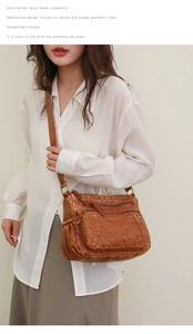 Detail der braunen Ledertasche mit Mehrfachreißverschlüssen und Vintage-Kupferbeschlägen