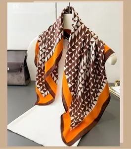 Detailed view of geometric herringbone silk scarf with brown and orange fan patterns