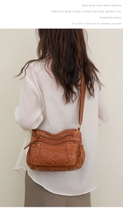 Detail einer braunen Umhängetasche mit vielen Taschen und weicher Lederstruktur