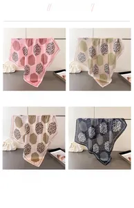Detail display of four leopard print silk scarves in pink, beige, white, and black colors