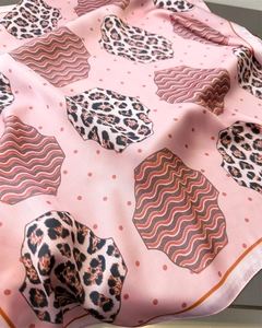 Close-up of leopard print and wavy patterns on light pink silk-like scarf fabric