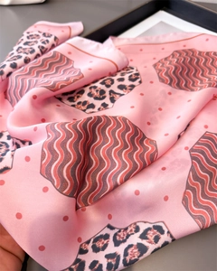 Detailed view of pink leopard print silk scarf with red wavy patterns and soft texture
