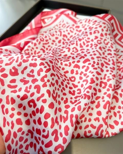 Detailed close-up showing the smooth silk texture and red leopard print pattern