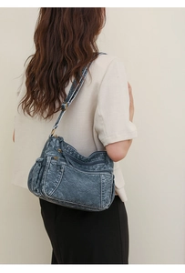 Model trägt eine große Multi-Taschen Umhängetasche mit Vintage-Waschleder-Textur