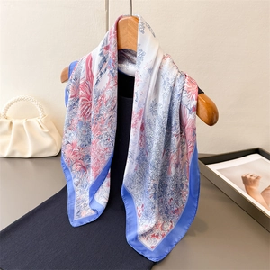 Eleganter Seidenschal mit Blumenmuster in Blau und Rosa an einem Holzkleiderbügel