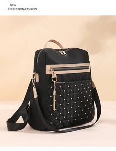 Detail of black backpack with gold rivets, quilted diamond patterns and metal chain