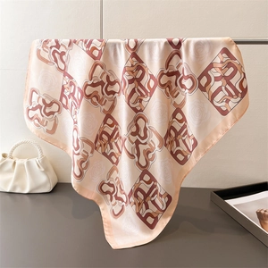 Detail of silk-like square scarf with floral print and abstract geometric patterns