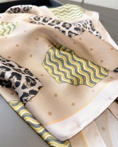Macro shot of luxury leopard print silk scarf showing texture and abstract patterns