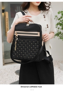 Detail view of black quilted nylon backpack with gold studs and smooth zipper tassels