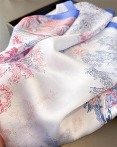 Nahaufnahme eines Seidenschals mit botanischem Aufdruck und Satin-Textur-Details