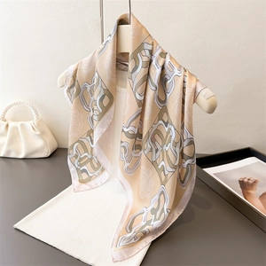 Elegant floral silk scarf with chain pattern on mannequin with pearl handbag