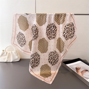 Detail of leopard print faux silk scarf with satin texture hanging on a metal rack