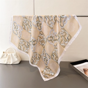 Detail of elegant beige silk square scarf with floral print and clean white edges