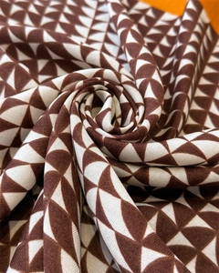 Detail of herringbone pattern square scarf with brown and cream geometric weaving texture