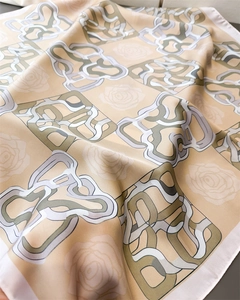 Detailed view of elegant floral and monogram pattern on smooth satin square scarf