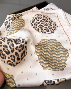 Close-up of leopard and wave pattern silk scarf showing luxurious texture and gold dots