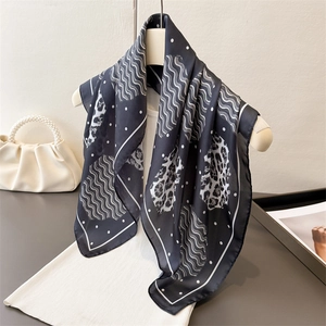 Leopard and polka dot print silk scarf draped elegantly on a display mannequin