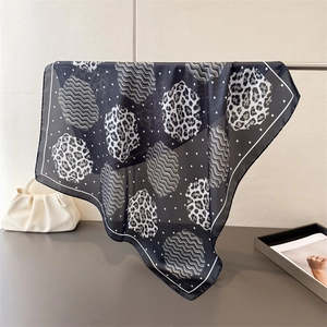 Macro detail of leopard and geometric print silk scarf hanging with a satin finish