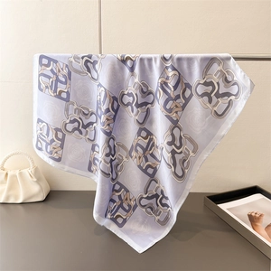 Detail of silk-like scarf draped on a metal rack showing smooth texture and floral pattern