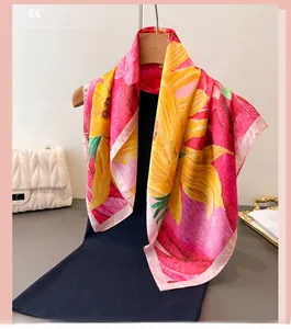 Close-up of elegant floral silk scarf featuring vibrant sunflower patterns and pink edges