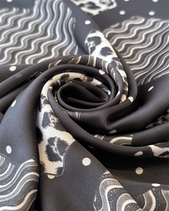 Macro shot showing silky texture of leopard print satin scarf with wave and dot patterns