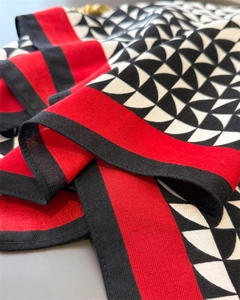 Close-up of geometric pattern cotton linen scarf with red borders and detailed stitching