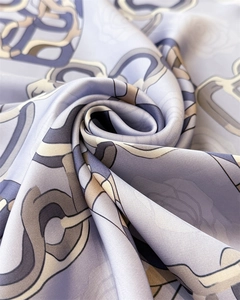Close-up of a soft lavender silk scarf featuring luxury chain and rose floral patterns