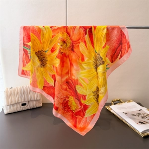 Detailed shot of vibrant floral silk scarf with sunflower print and elegant pink border