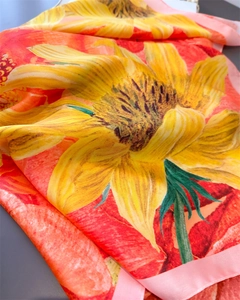 Detail of silk scarf showing vibrant sunflower print and soft draping texture