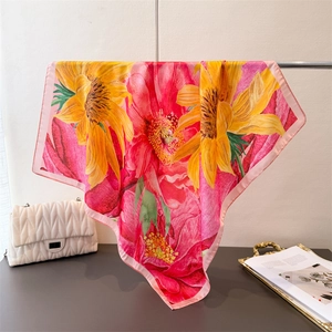 Detail of floral silk scarf featuring sunflower prints and pink stitched edge texture
