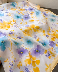 Close-up of floral print silk scarf with satin finish showing soft folds and texture