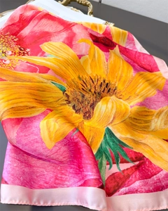 Detailed view of vibrant sunflower silk scarf with elegant satin luster and pink floral print