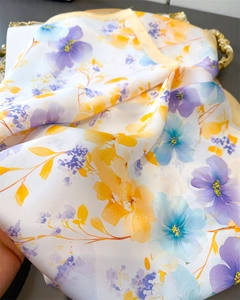 Detail of floral print silk scarf with golden outlines on an ornate tray