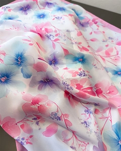 Macro shot of silk-like floral scarf fabric showing light textures and soft draping