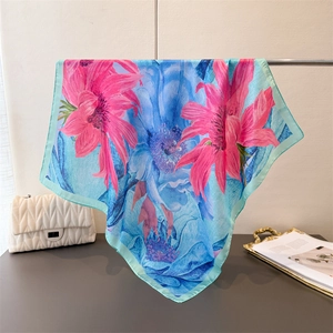 Detail of blue silk square scarf with pink floral print and elegant satin luster texture