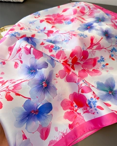Detail of floral silk scarf featuring pink and blue flowers with a soft satin finish