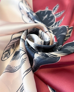 Detailed close-up showing the smooth satin texture and floral print of the silk scarf