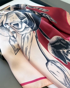 Macro detail of silk scarf with red rose print and fine rolled edge texture