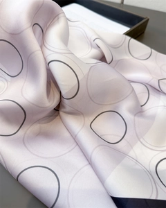 Detail of silk-like scarf fabric in light pink purple with grey circular print patterns