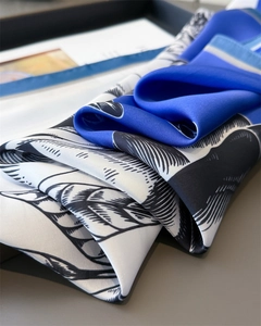 Detail of silk satin scarf showing blue and white leaf patterns and smooth texture