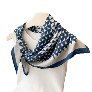 Navy and white geometric triangle pattern scarf draped on a white mannequin stand