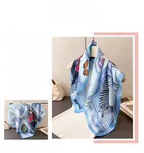 Detail view of square silk scarf with zebra and floral print on light blue border