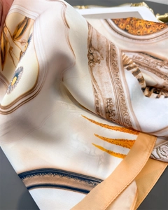 Close-up of luxury faux silk scarf featuring vintage patterns and orange rolled edges