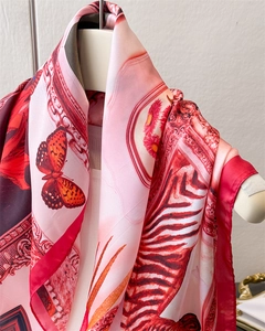 Close-up of silk scarf with baroque floral and butterfly prints on a beige mannequin