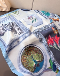 Detailed view of silk square scarf featuring zebra, peacock, and floral oil painting prints