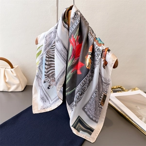 Elegant vintage silk scarf with zebra and floral print on a wooden hanger