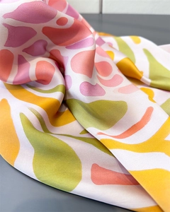 Gros plan du foulard en satin imprimé corail avec texture lisse et motifs abstraits colorés