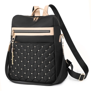 Fashionable black and tan backpack with quilted pattern and gold stud accents
