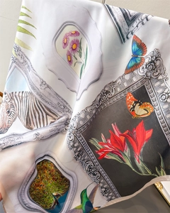 Detail of vintage floral silk scarf with peacock and zebra prints on white fabric